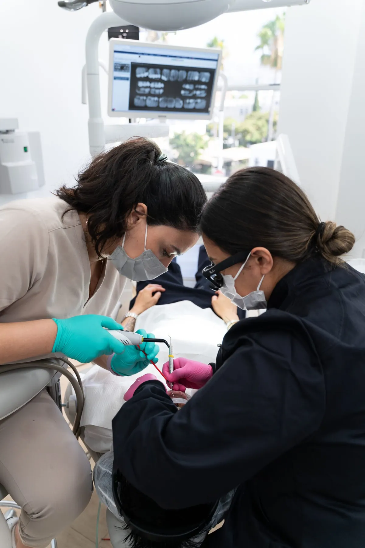 Dr. Andi-Jean Miro working chairside under magnification with her assistant