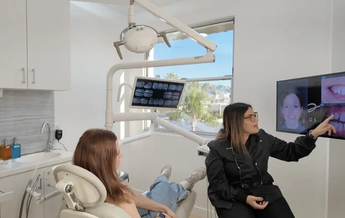 Dr. Andi-Jean Miro reviewing smile photos and X-rays with a patient during a veneers consultation